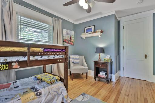 A sun-filled third bedroom boasting elegant crown molding and polished hardwoods. This inviting space offers a peaceful atmosphere with plenty of room for versatile furniture layouts.