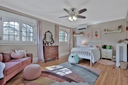 Generously sized second bedroom bursting with charm! Highlighted by unique arched windows and crown molding, this sun-filled space offers a perfect blend of historic soul and comfort.