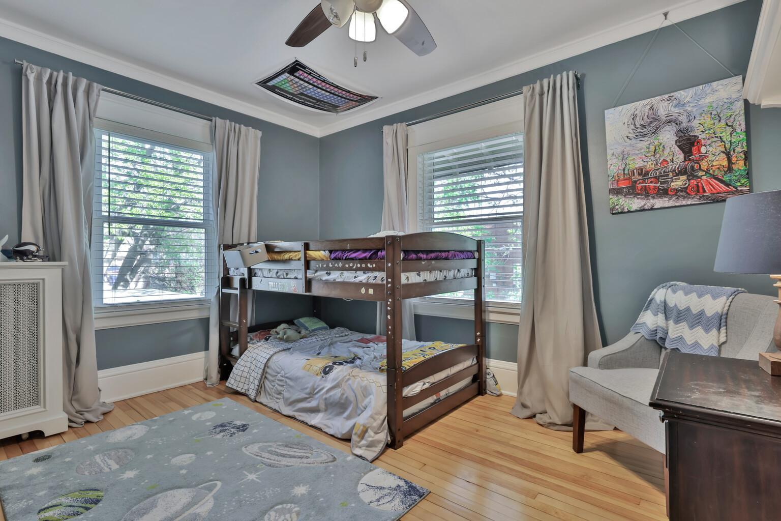 A sun-filled third bedroom boasting elegant crown molding and polished hardwoods. This inviting space offers a peaceful atmosphere with plenty of room for versatile furniture layouts.