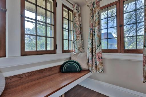 This cozy landing features a custom built-in wood bench, perfect as a sun-drenched reading nook. Surrounded by original windows, itâs a charming spot to pause and enjoy the view.
