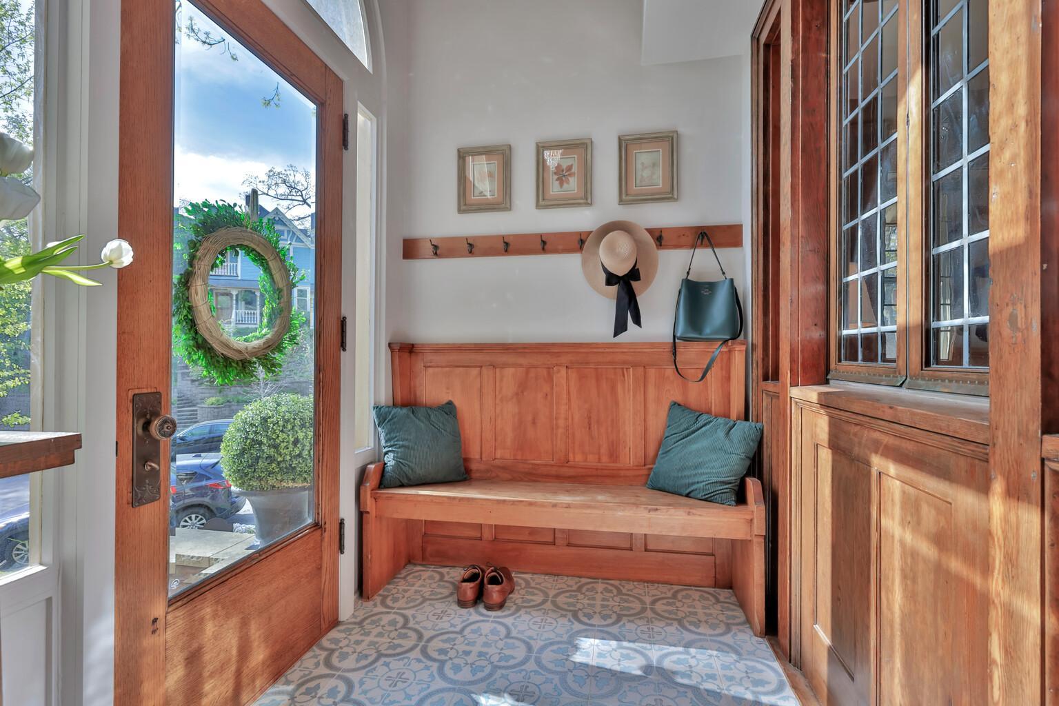 A stunning first impression! This enclosed front porch features a designer patterned heated tile floor, a charming A bright, sun-filled space.