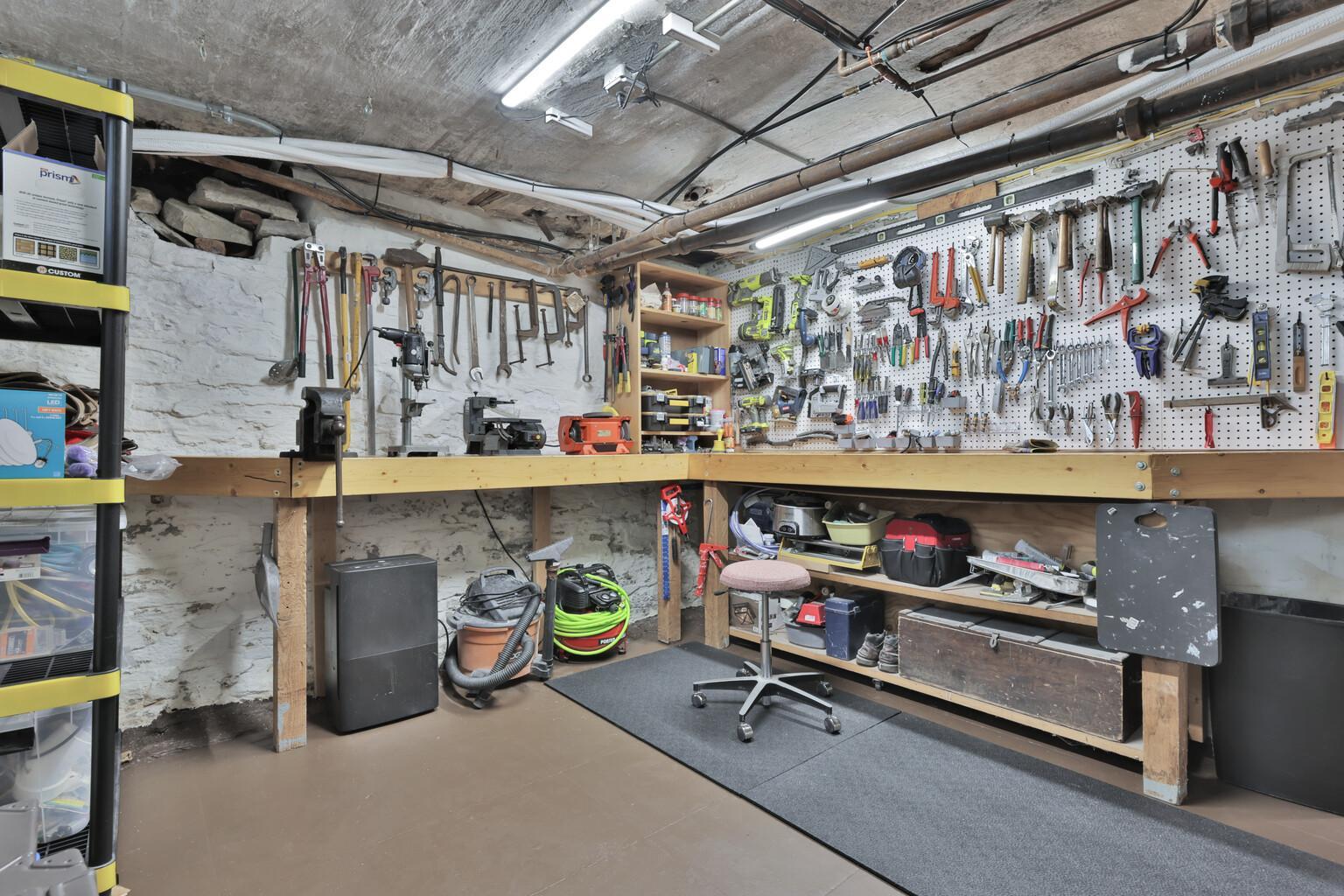 Large, functional workshop with a built-in L-shaped workbench and extensive storage. A bright, organized space perfect for any project or hobby.