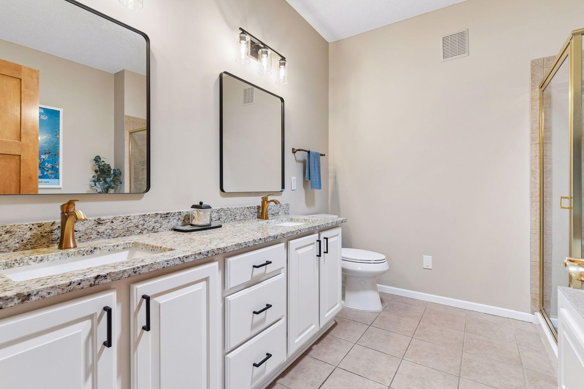 Freshly updated, the Primary Bath offers an enameled double vanity with granite countertops, new fixtures and faucets and designer mirrors.