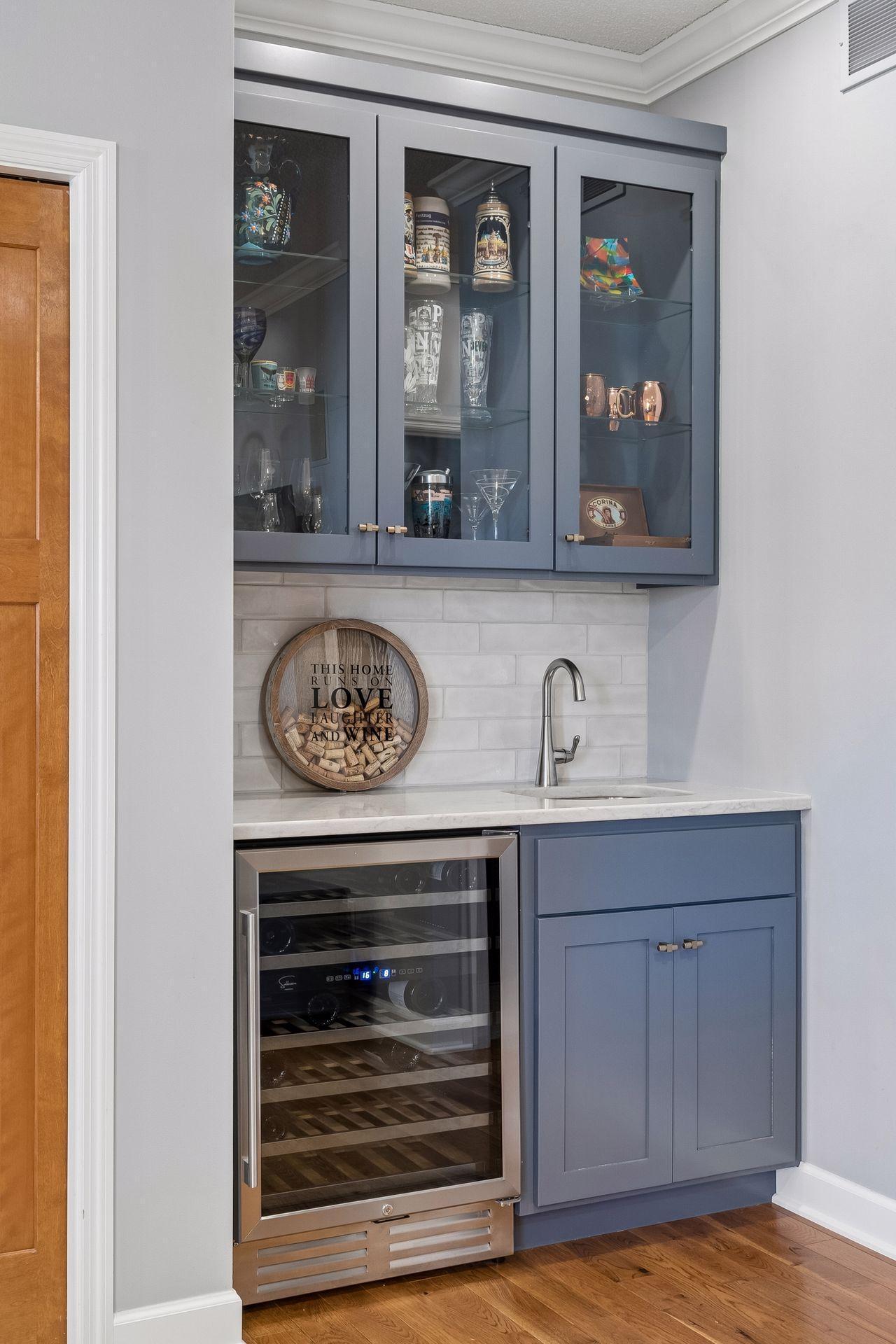 Great for entertaining, the walk-up bar features custom cabinetry, a beverage refrigerator and quartz countertop.