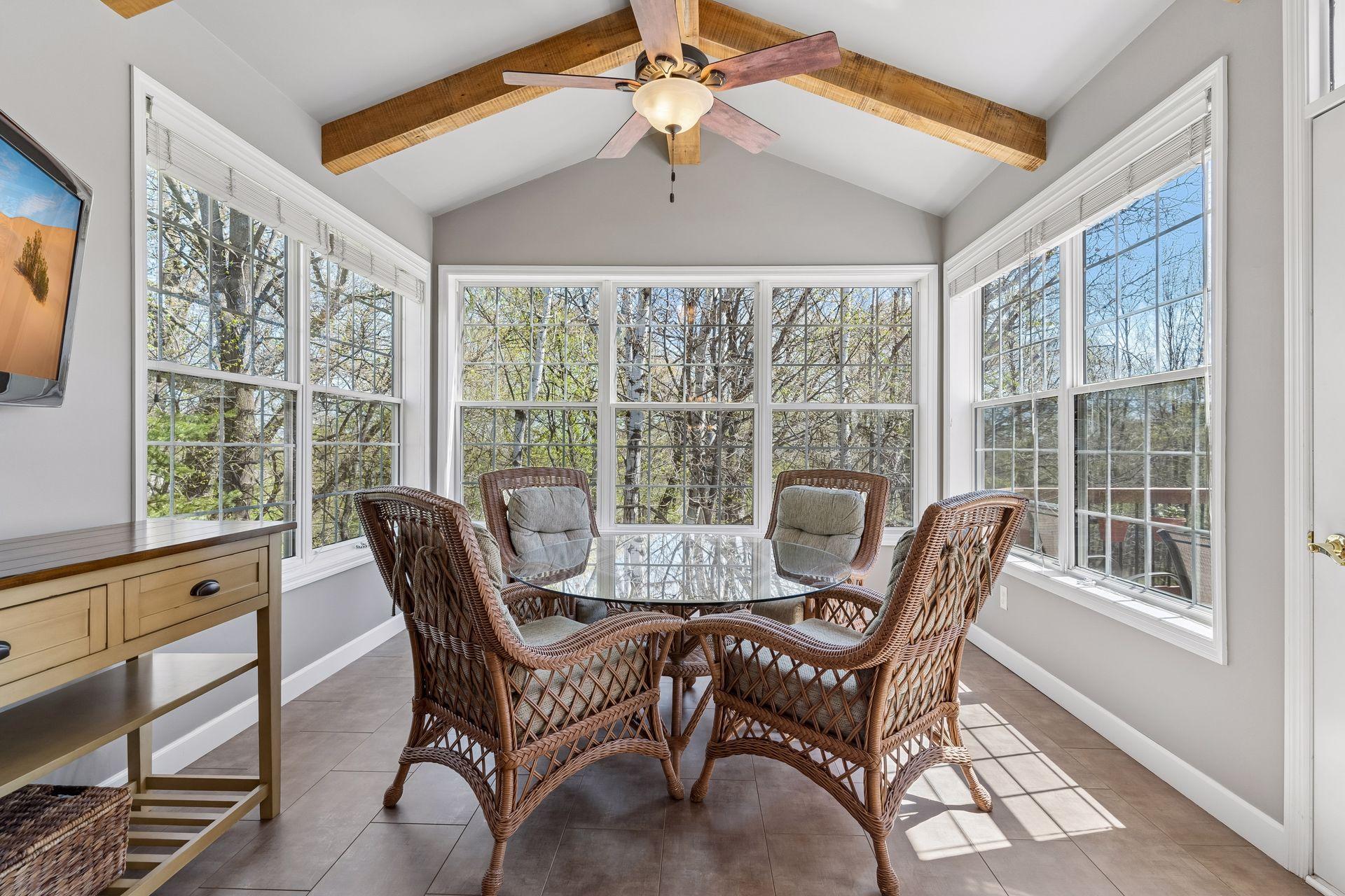 The vaulted Sun Room is a cozy space with heated tile flooring and beautiful reclaimed wood beams.