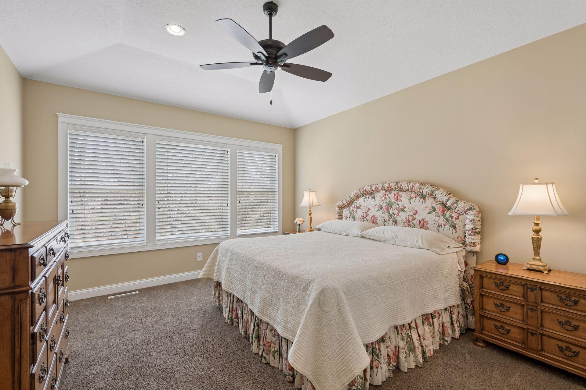 Primary bedroom with vaulted ceiling and fan