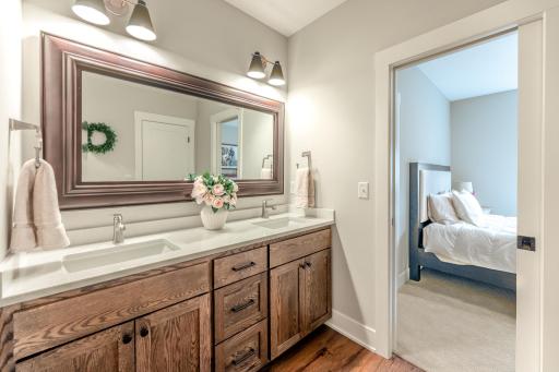 The lower level full bath features dual sinks and offers the ultimate convenience with both private bedroom walk-through access and separate hallway entry.