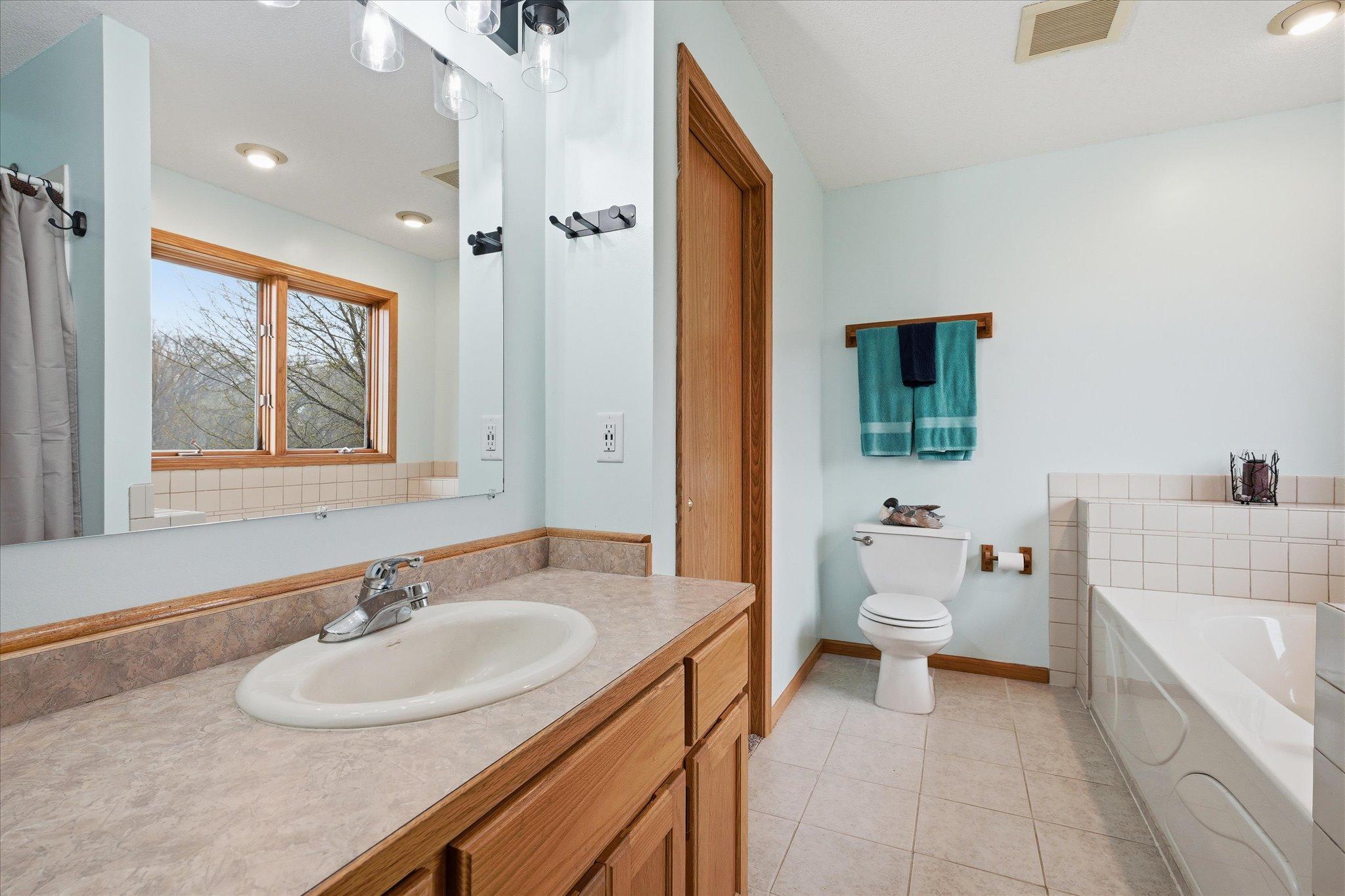 Primary bathroom featuring walk in closet and separate tub and shower
