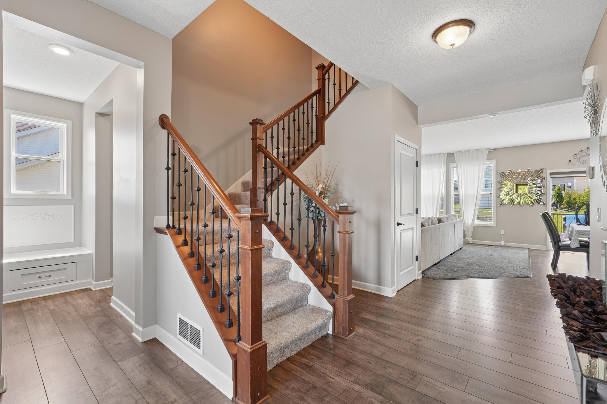 Greeted by beautiful staircase with open floor plan
