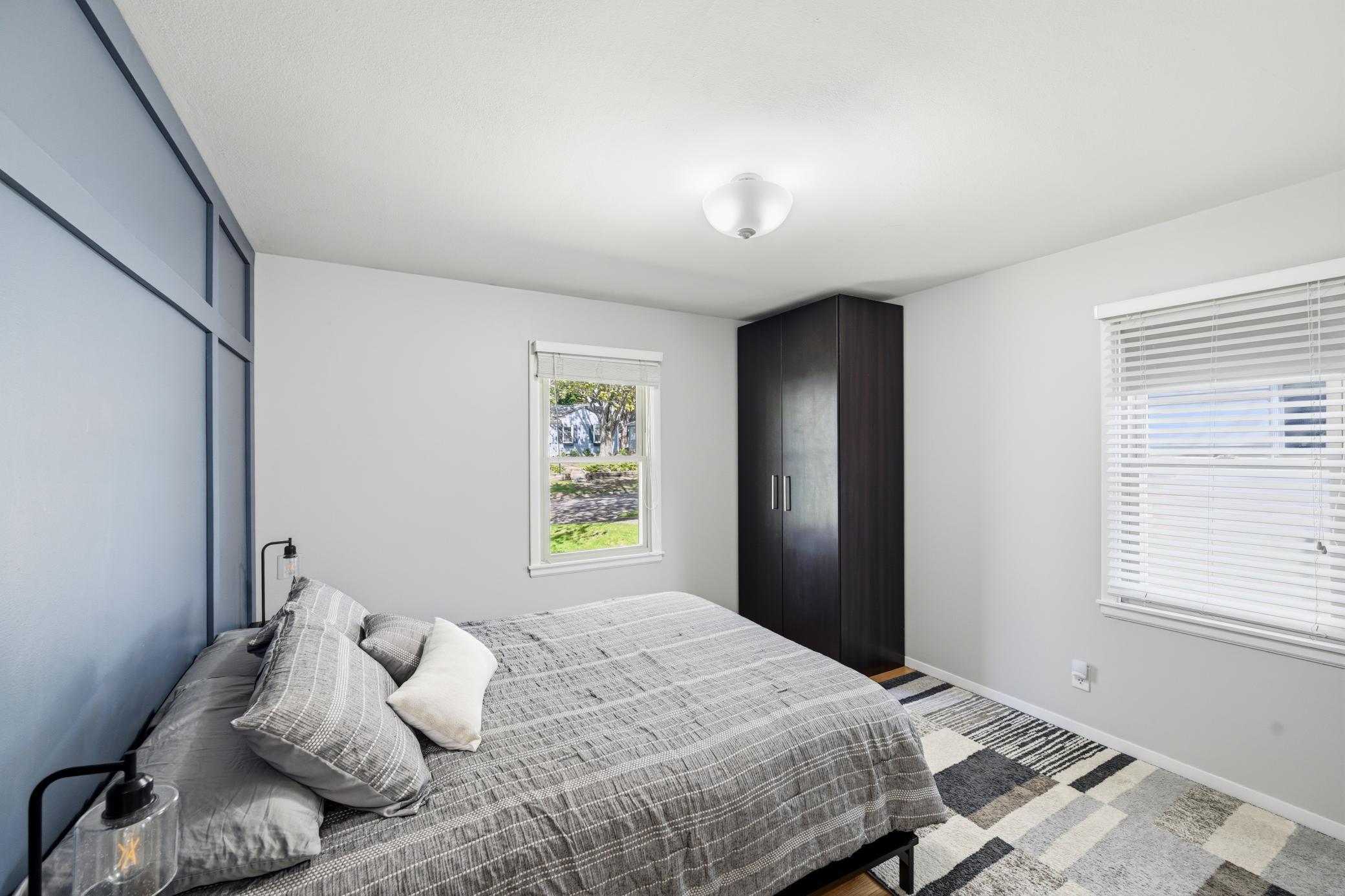 The primary bedroom has hardwood floors and a beautiful feature wall.