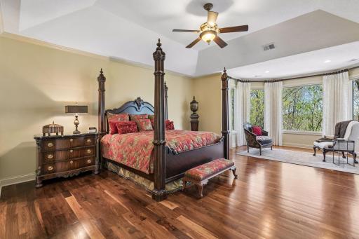 Luxurious primary suite with walnut floors and double-door entry
