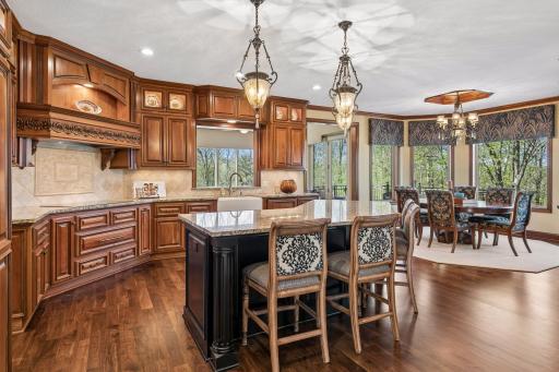 The spacious kitchen with rich American cherry cabinetry opens to the informal dining room
