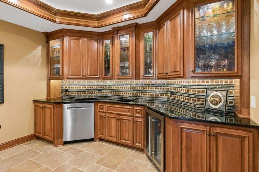 The wet bar features granite surfaces and decorative ceiling detail