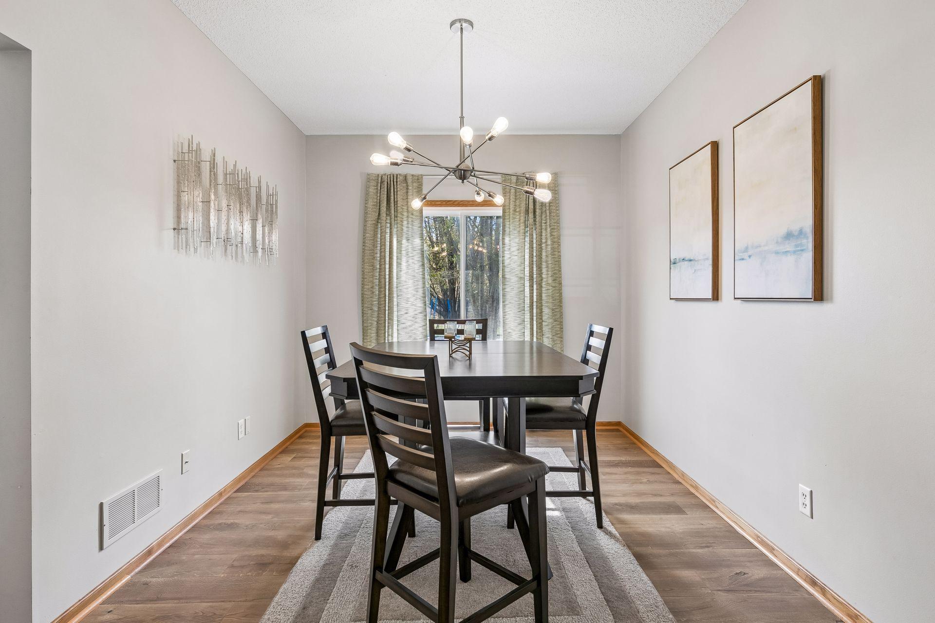 The formal dining room, accented with modern lighting, is ideal for gatherings and entertaining.