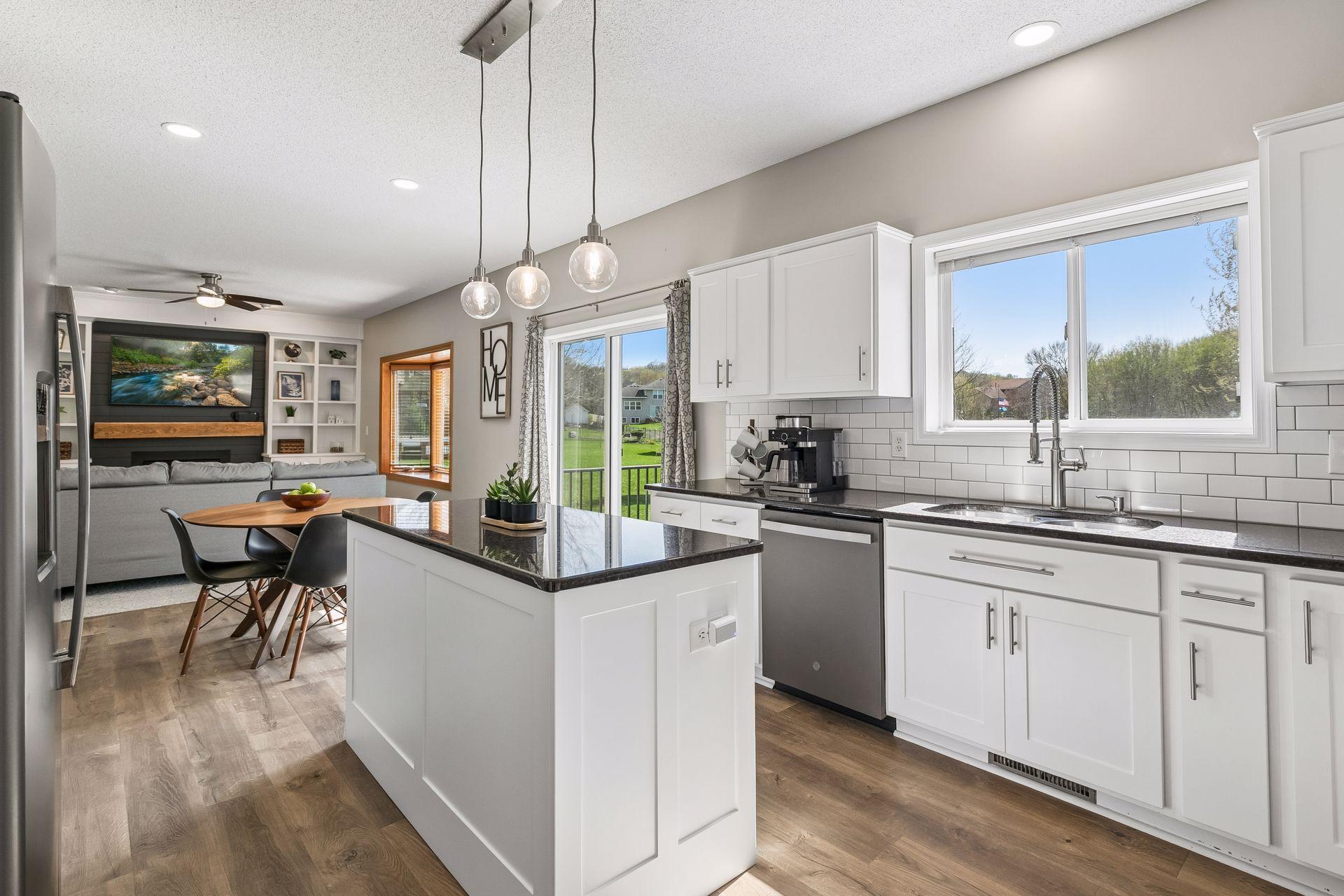 The kitchen has been remodeled with white cabinetry, granite countertops, stainless steel appliances, and a functional center island.