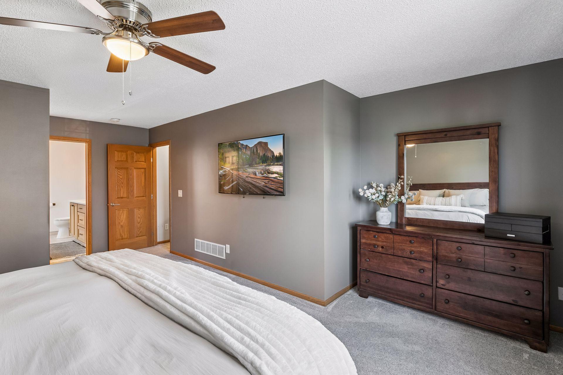 This view of the primary bedroom offers a glimpse of the brand-new primary private bath. A walk-in closet is located just outside the bathroom.