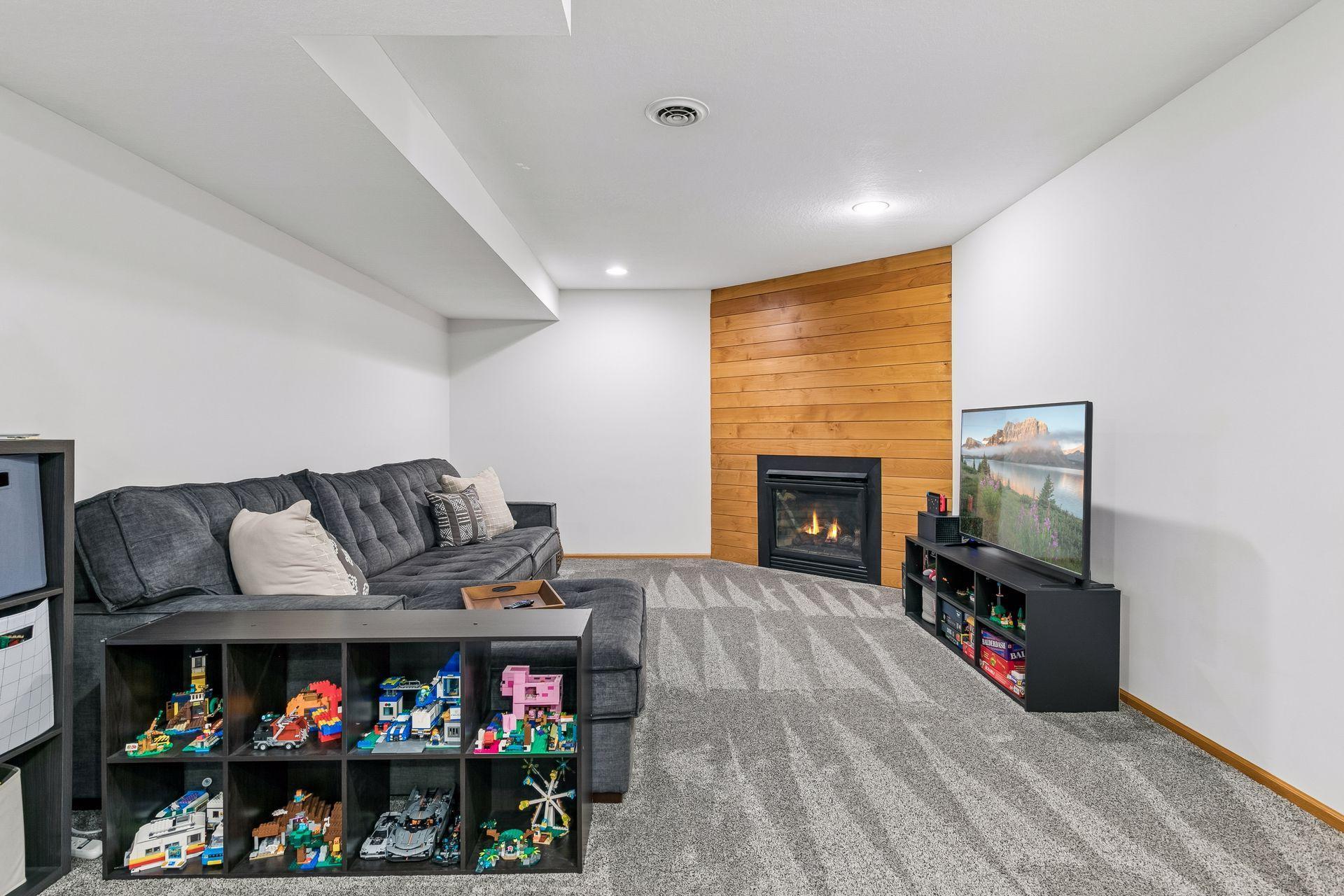The lower level offers a second family room with an additional gas fireplace surrounded by knotty alder shiplap. This is the perfect spot for movie nights or entertaining.