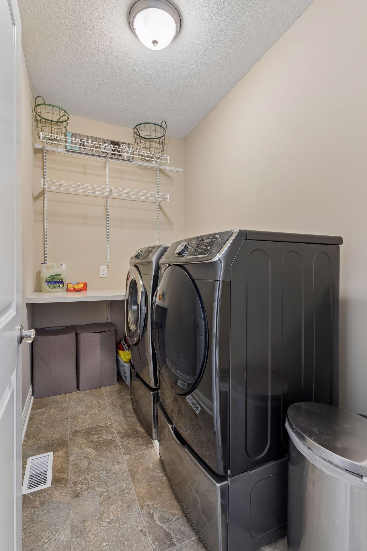 The laundry room is located on the upper level. It has great storage and counter space too.