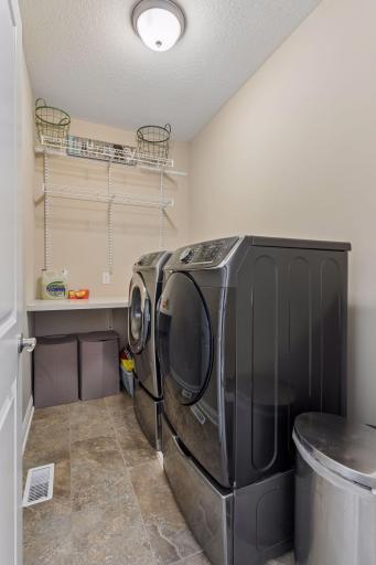 The laundry room is located on the upper level. It has great storage and counter space too.
