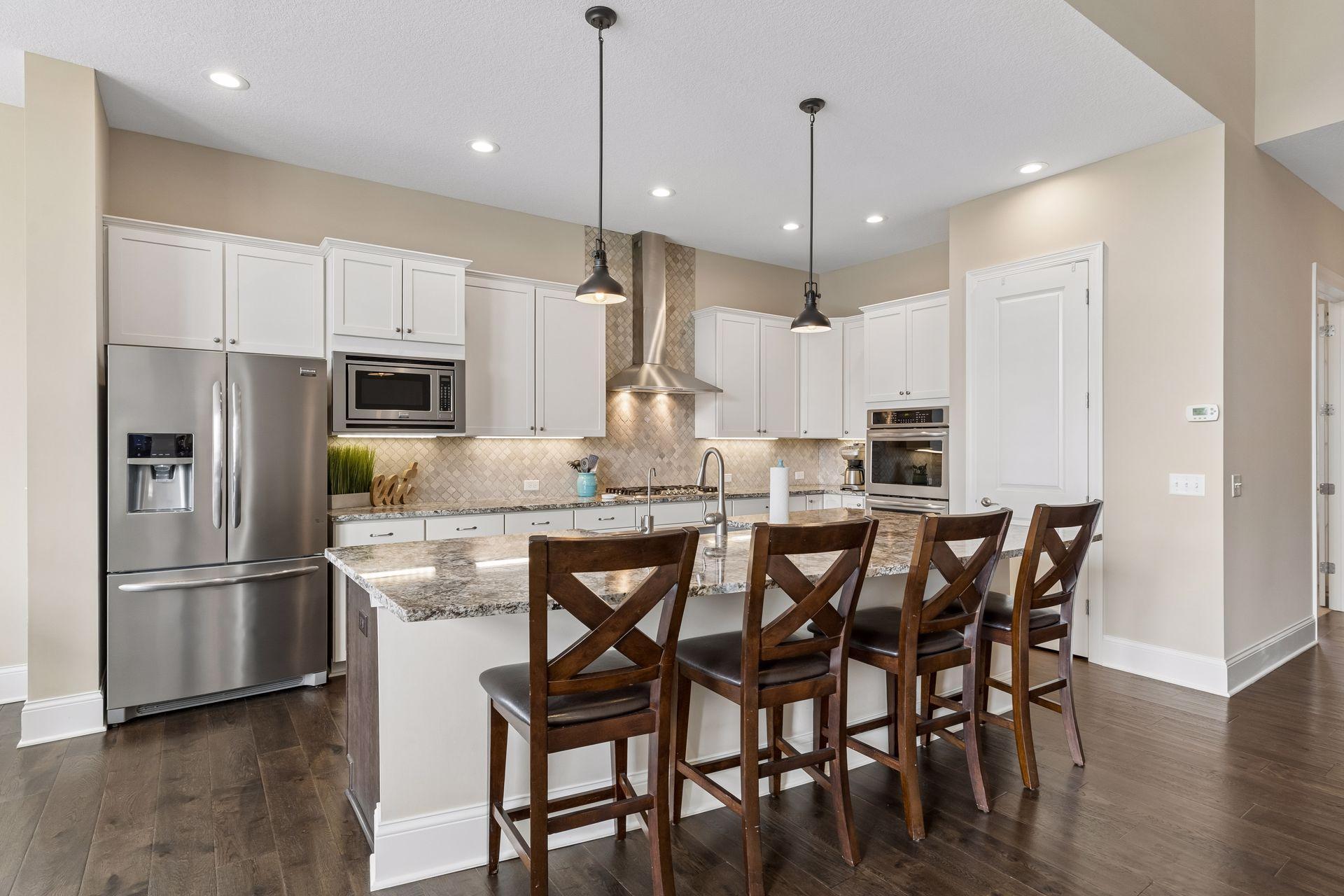 The large granite kitchen island is a centerpoint for all to mingle. It's a stunning setting.
