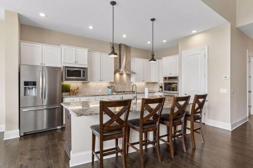 The large granite kitchen island is a centerpoint for all to mingle. It's a stunning setting.