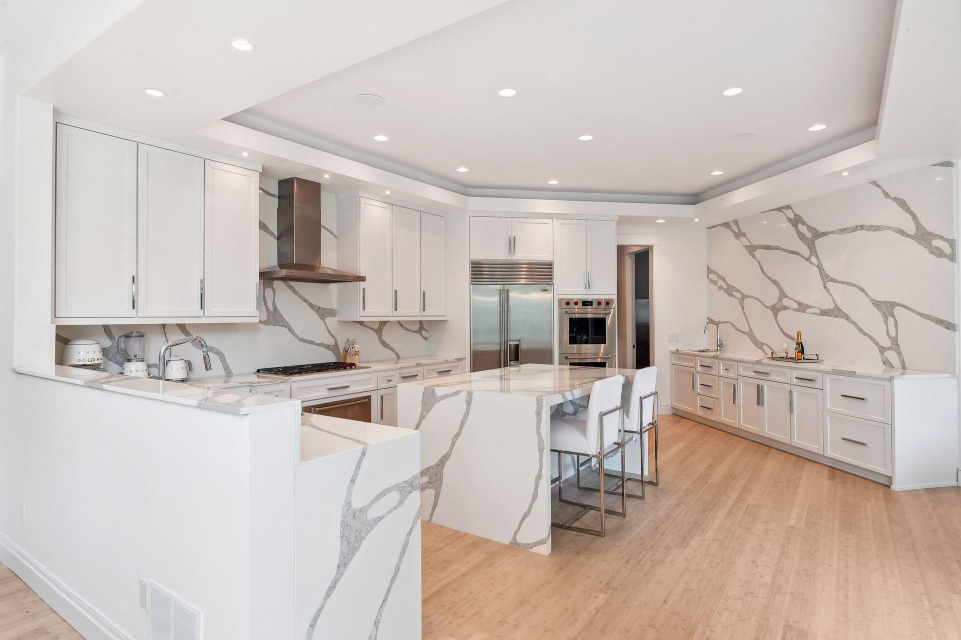 Sleek custom cabinetry, dramatic veined quartz backsplash, and ample cabinet space