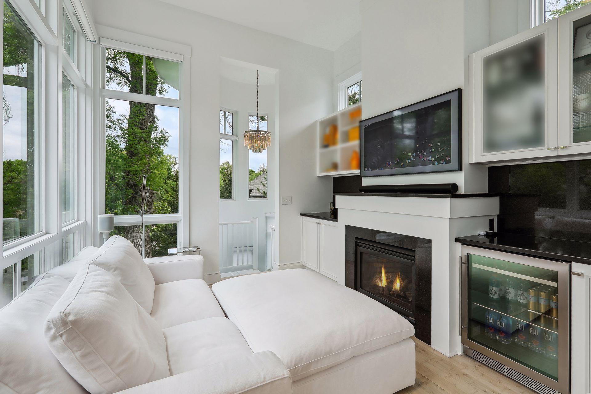 Primary bedroom sitting room with gas fireplace and beverage fridge for ultimate relaxation. Spiral staircase leads down to the lower level.