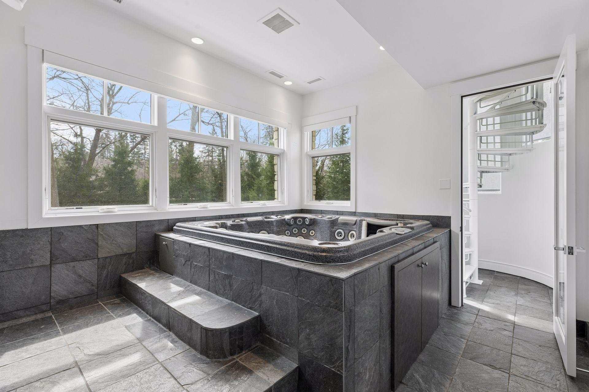 Hot tub room just off the lower level exercise room, staircase leads up the primary bedroom