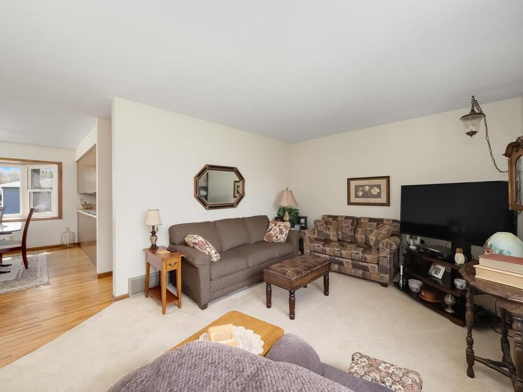 Living room is carpeted . Hardwood flooring in dining room