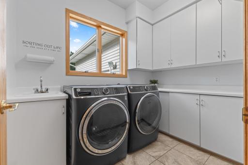 Bright and inviting main floor laundry room. It even has a laundry chute drop from the upper level. Newer washer and dryer will stay.