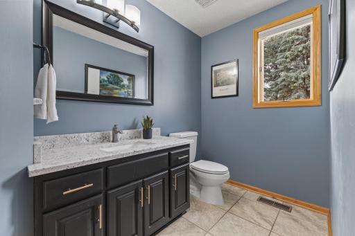 Spacious main floor half-bath with granite countertop