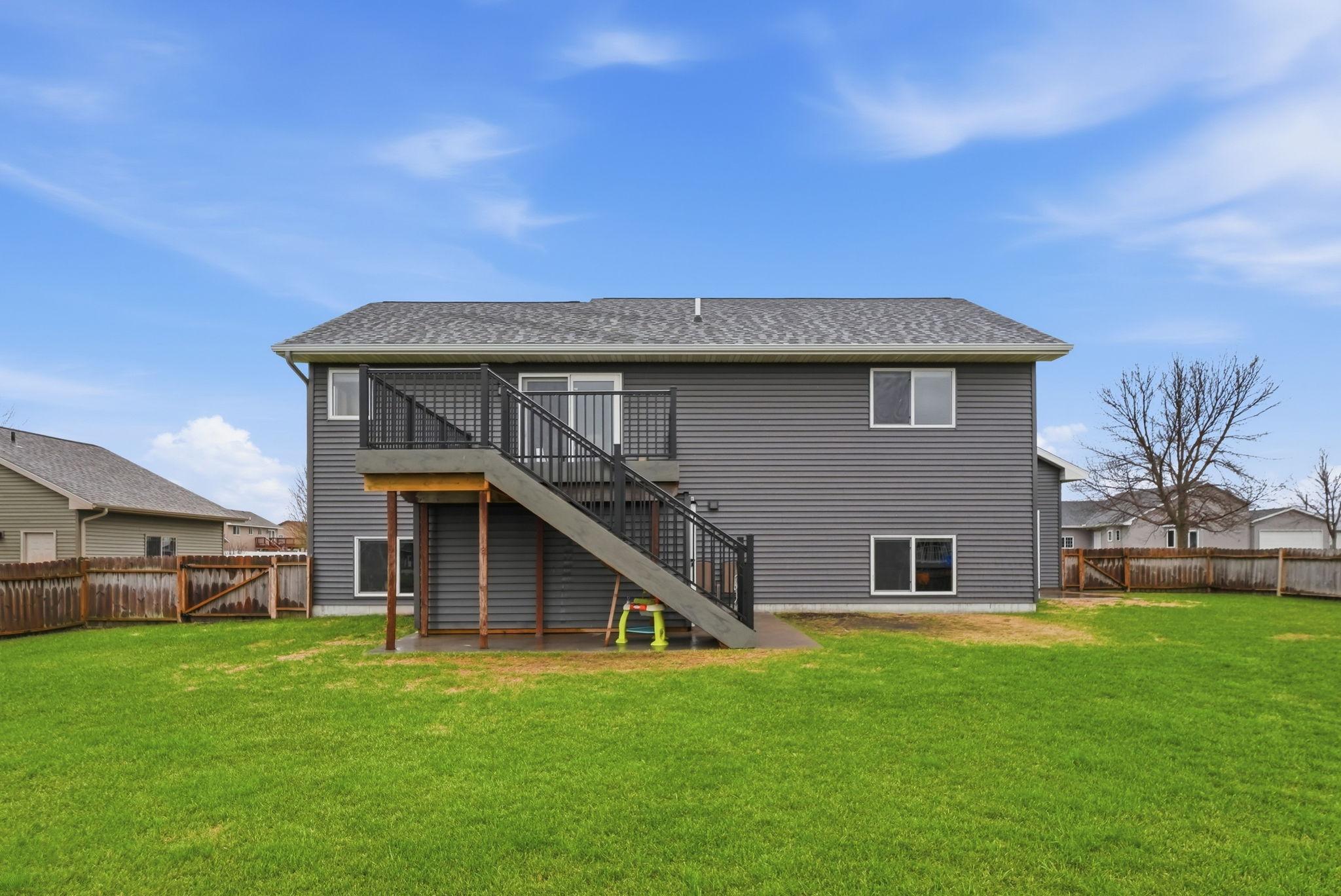 View of the back of the home, deck walks down to the backyard.