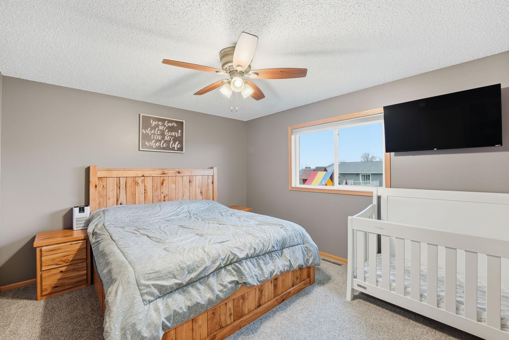 Spacious primary bedroom with plush carpeting.