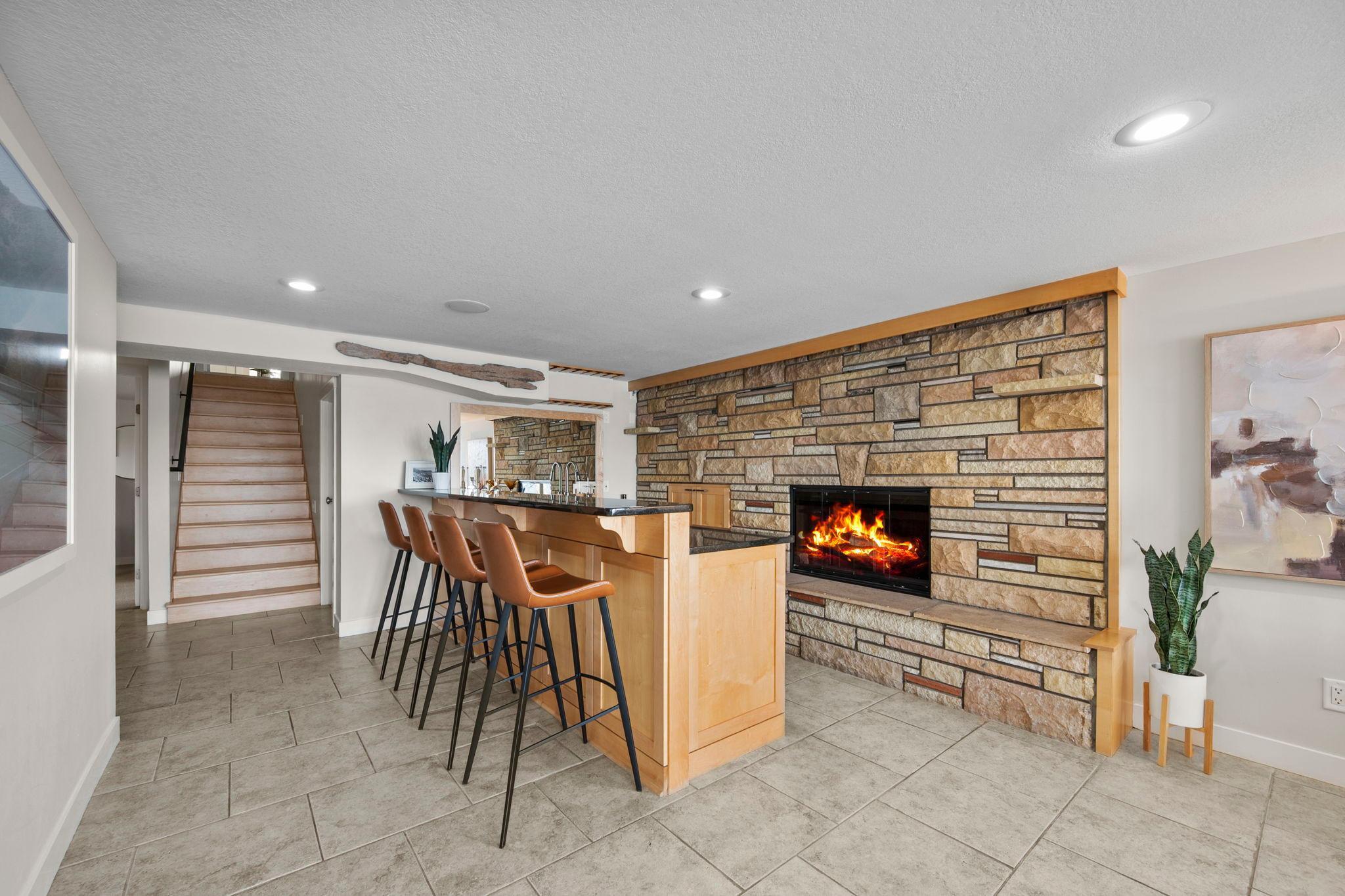 Custom wet bar with stone fireplace.