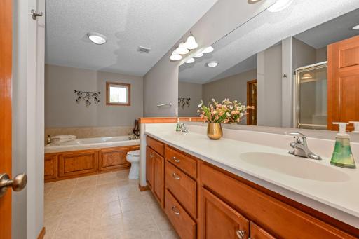 Primary suite bath with dual sinks and heated tile floors to start your day.