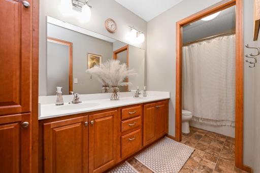 Upper bath with dual sinks and doorway leads to shower/tub area.
