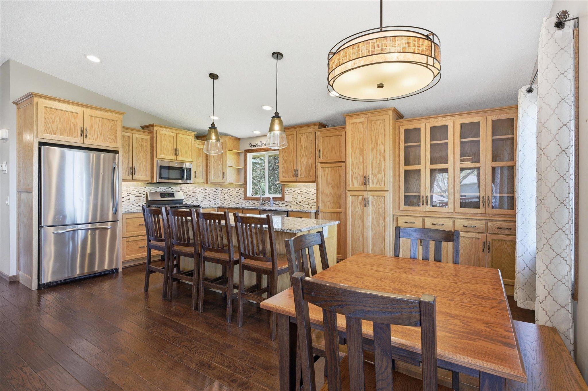Stainless steel appliances, granite countertops, tile backsplash, and updated lighting adds to the elegance of this custom kitchen.