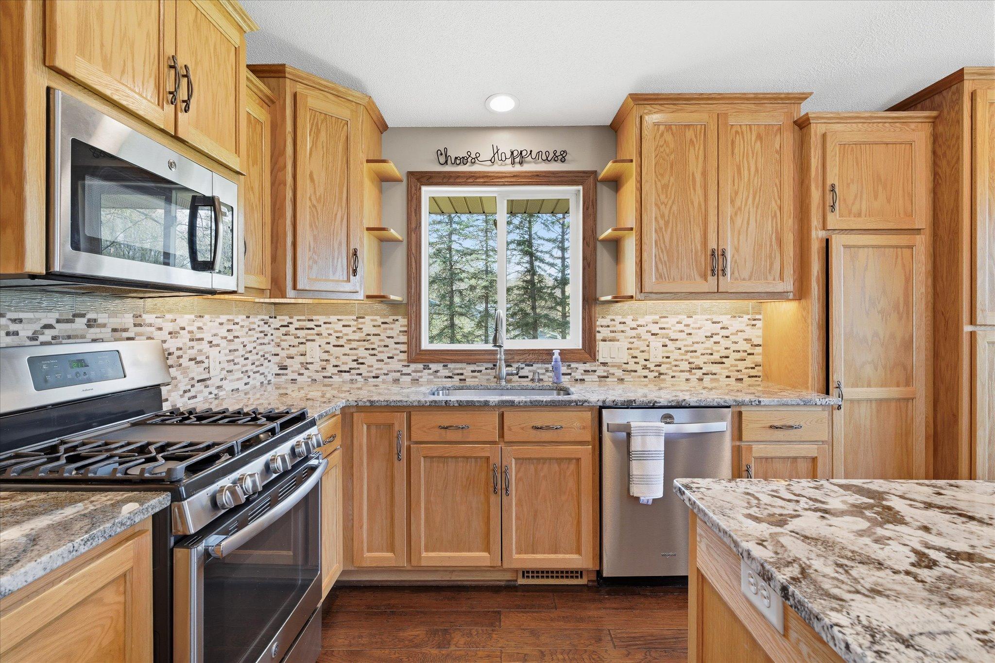 Another view of the kitchen....note stainless appliances and the fun custom shelves surrounding the kitchen window.