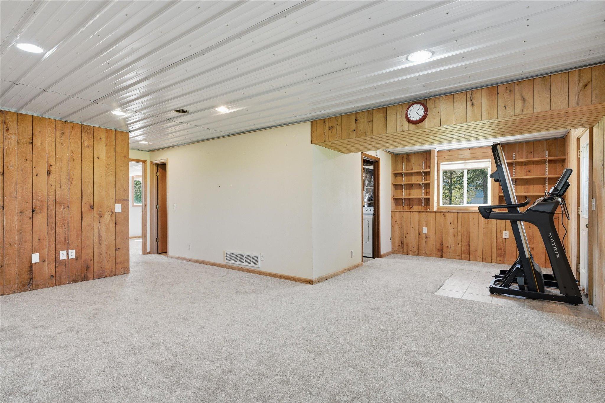 Near the walkout area of the lower level is built in shelves which are perfect to showcase favorite items, books, etc. The treadmill in front of the walkout door will be removed. It was moved to that spot so that the new carpet could be installed