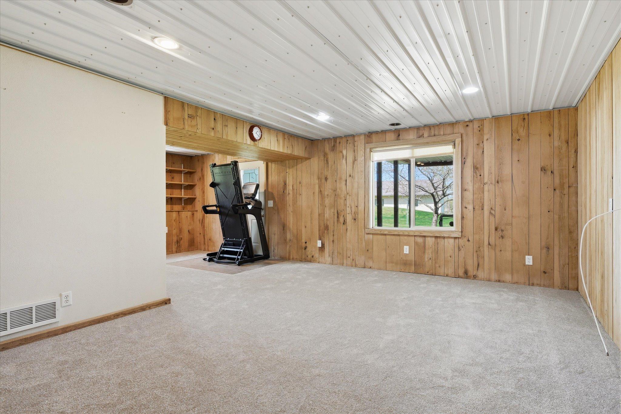 View of the walkout area in the family room. The entire lower level has brand new carpeting. The treadmill in front of the door will be removed and was moved there for the carpet to be installed.