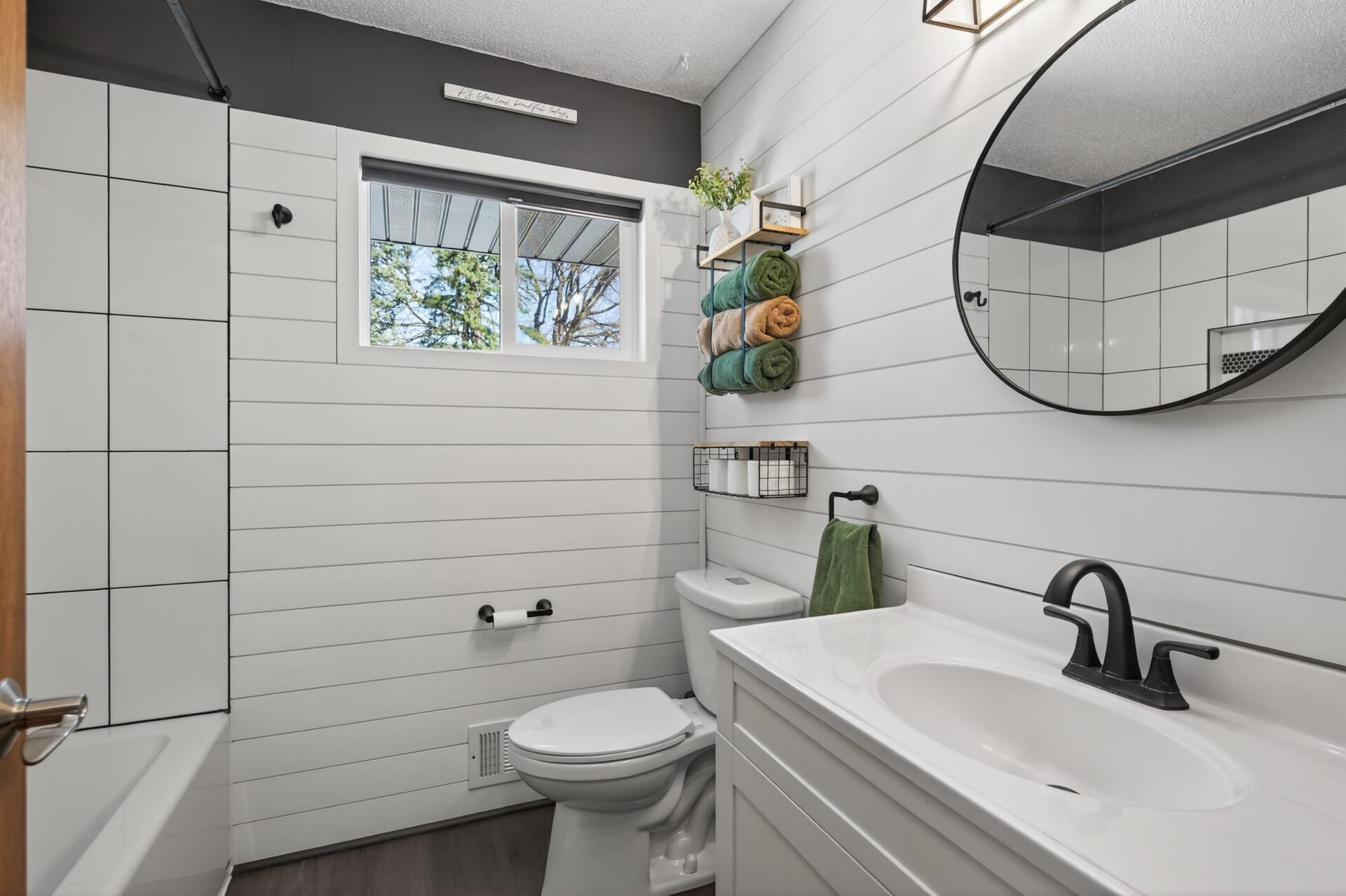 The full bathroom features charming shiplap, a crisp white vanity, and stylish, on-trend hardware. Located near both upper level bedrooms and all other living spaces making it ideal for guests and everyday use.