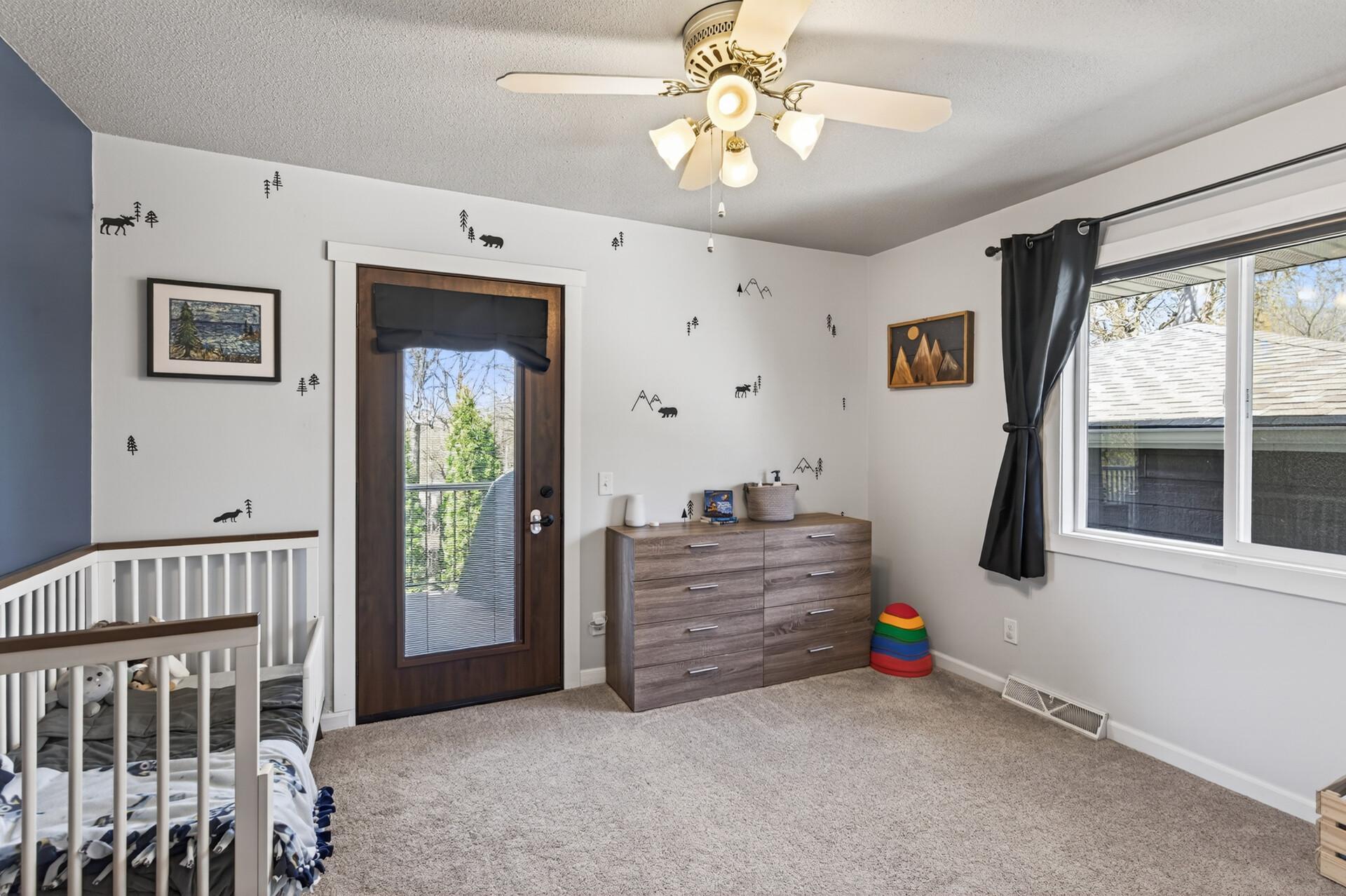 Second upper level bedroom also offers neutral tones, abundant natural light, and a ceiling fan.