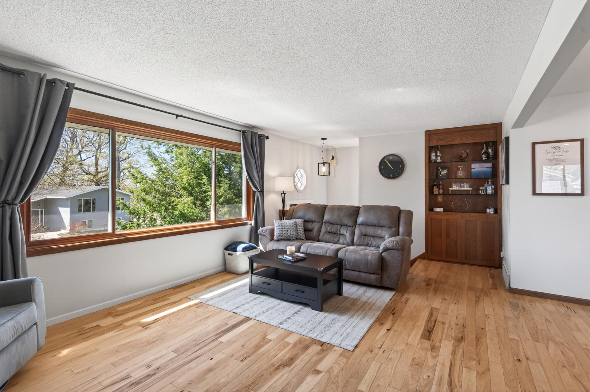 A large picture window fills the space with natural light, creating a warm and inviting atmosphere.