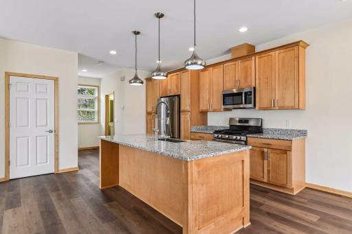 Stunning kitchen with granite countertops and all new, never used stainless steel appliances and cabinetry.
