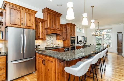 Kitchen flows into a light-filled dining area with large windows and an updated chandelier.jpg