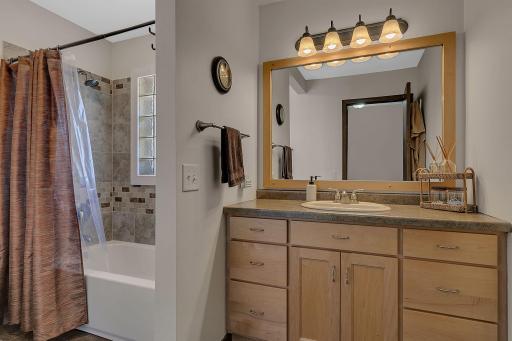 Main floor full bath features beautiful maple cabinets