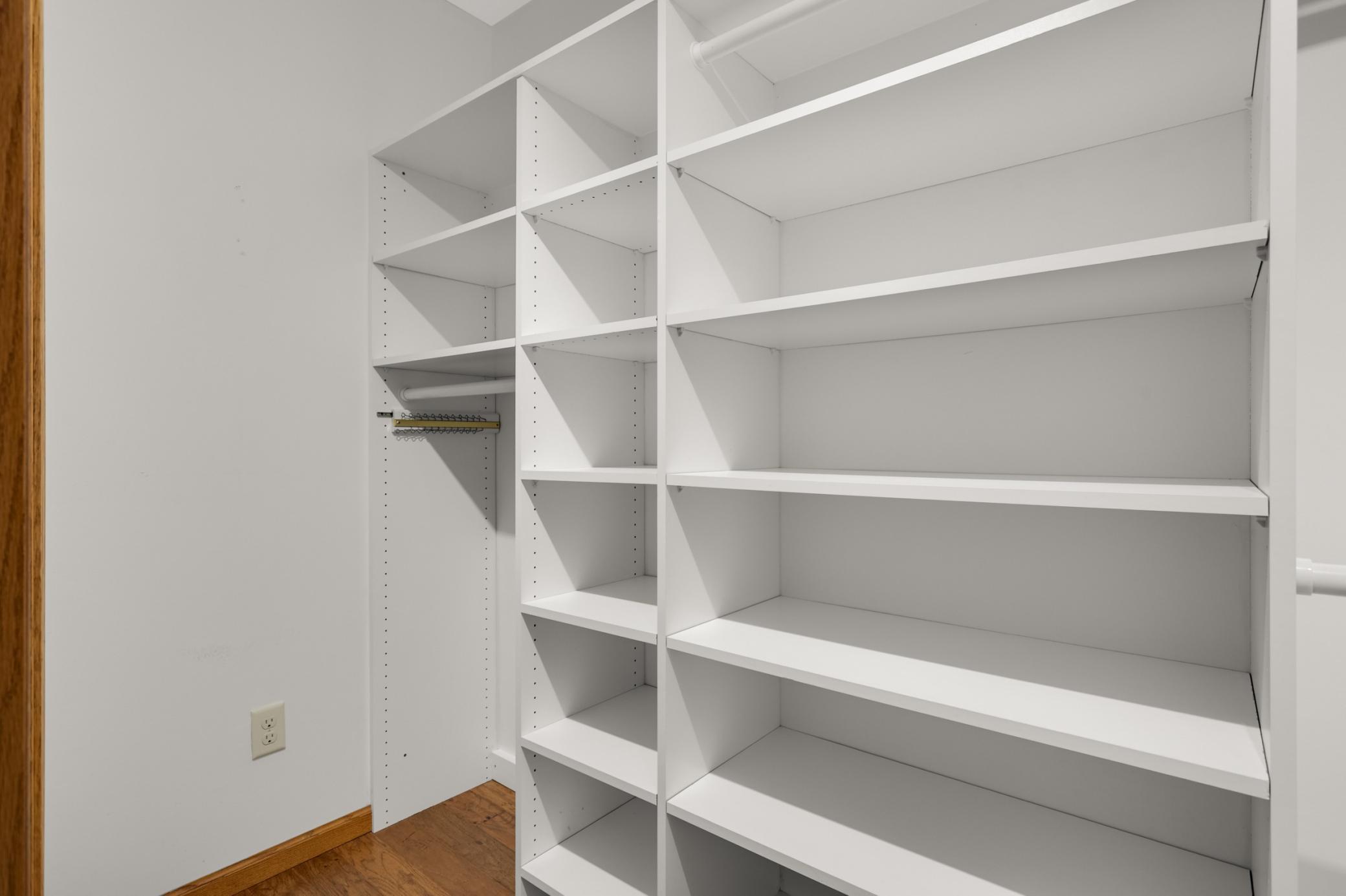 Large walk in closet with all these built in shelves.