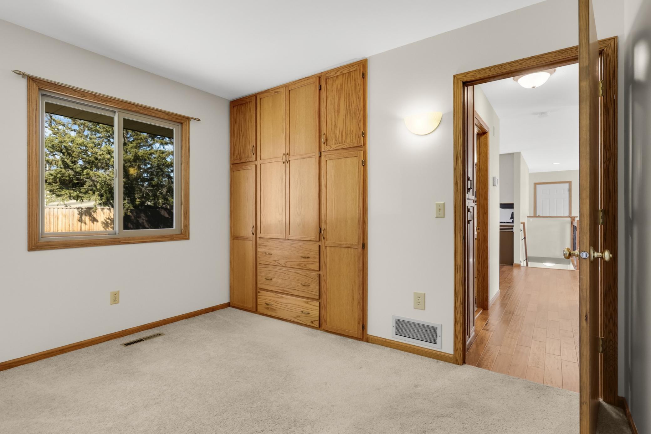 2nd bedroom on upper level has built in cabinets.