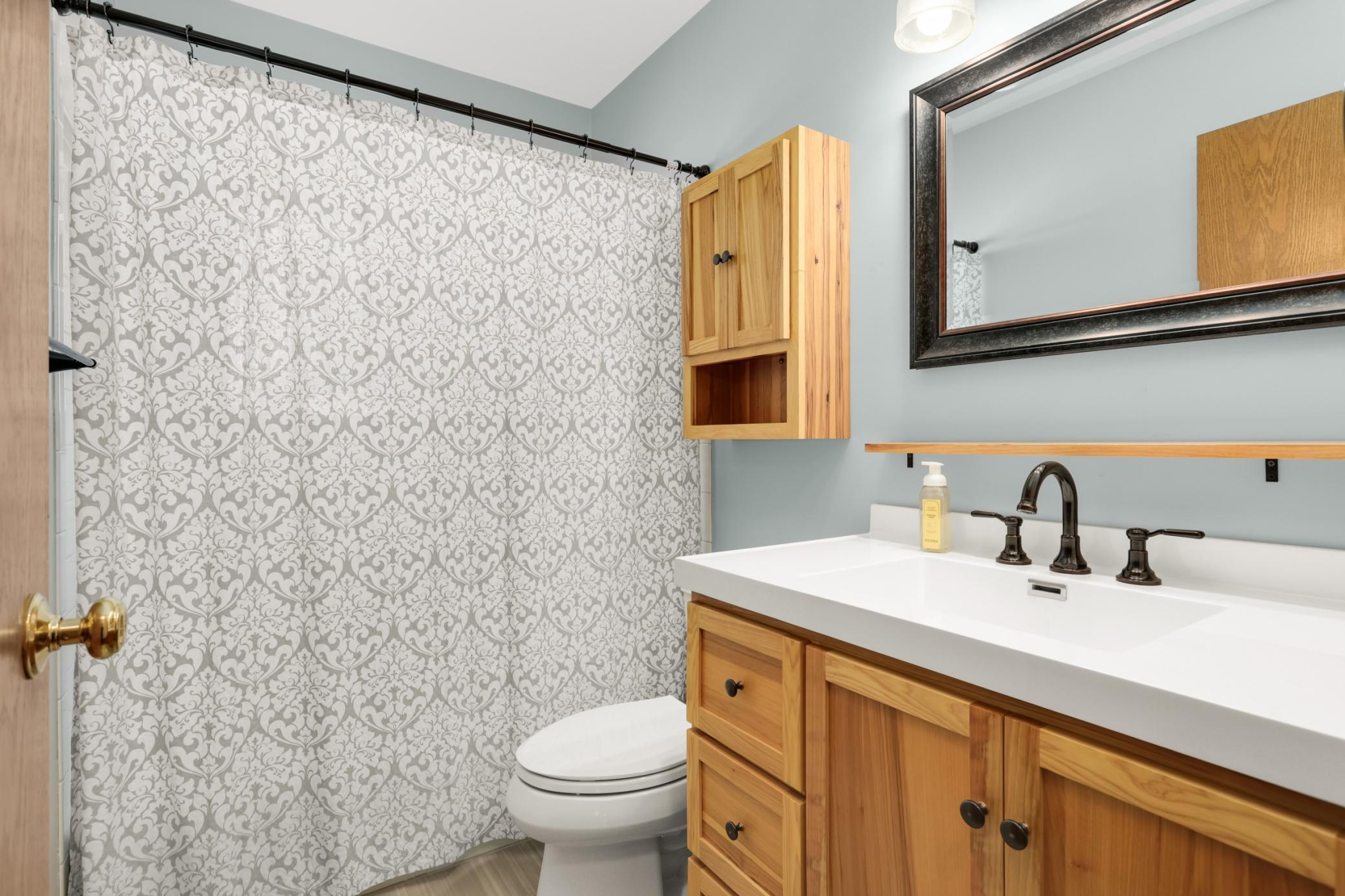 Main floor bath remodleld with hickory cabinets, cermamic flooring, and tub and shower are ceramic too.