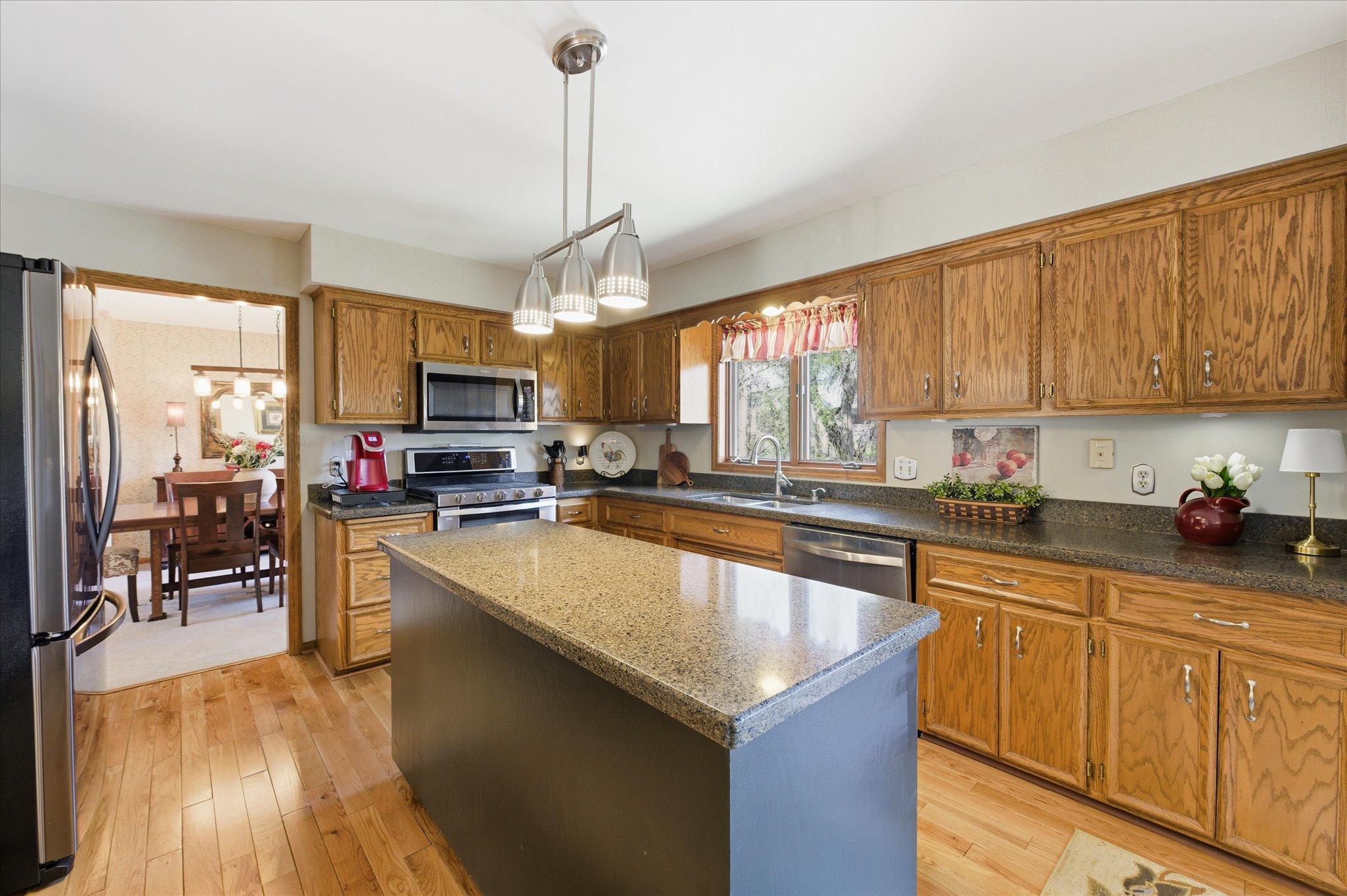 Large kitchen features gorgeous hardwood flooring, granite countertops and stainless steel appliances.
